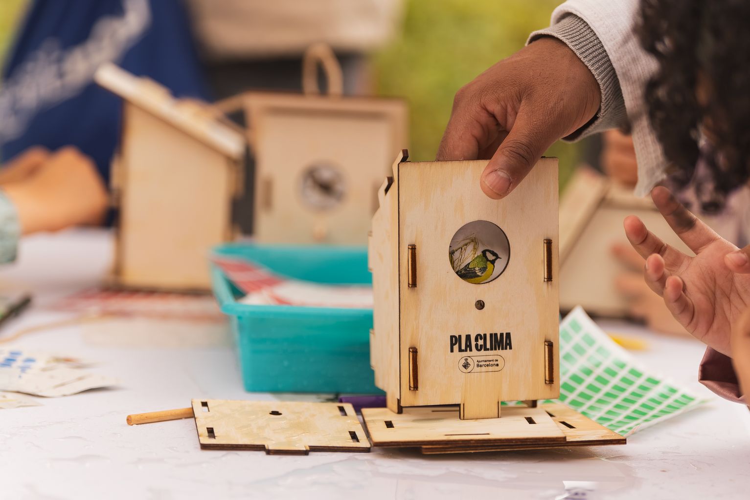 Un infant construeix una casa d'ocell del Pla Clima el dia de la inauguració del parc de les Glòries