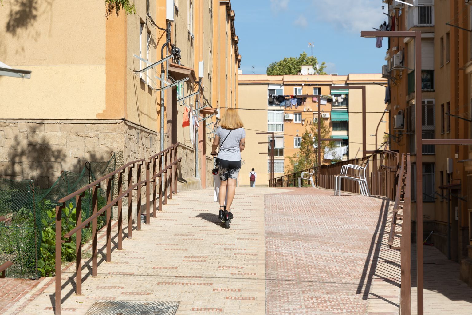 Una dona circula en patinet per una de les rampes d’accés a la zona d’edificis dels carrers d’Aiguablava i Portlligat creades per millorar l’accessibilitat i que forma part d’un projecte de reurbanització del Pla de barris