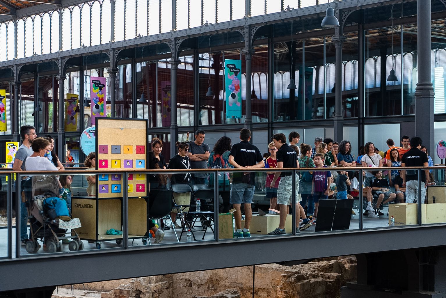 Assistents al Taller Explainers de la Festa de la Ciència 2024 a una passarel·la d'El Born