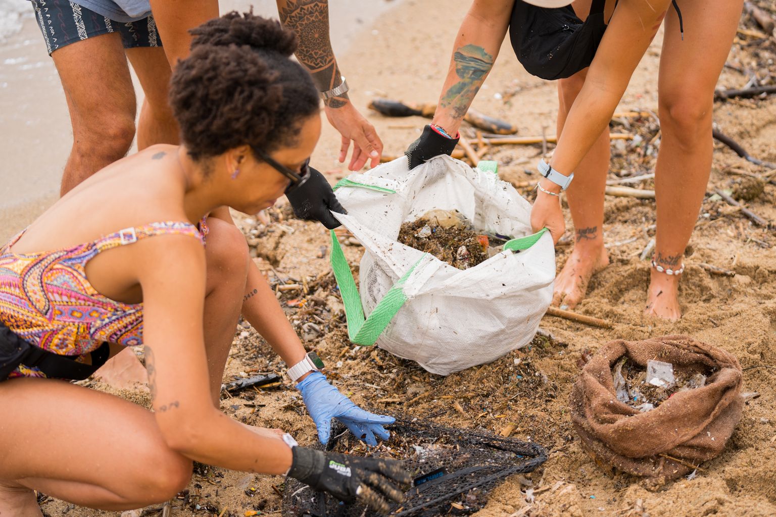 Voluntaris recollint residus de la sorra de la platja de la Barceloneta amb motiu del Dia Mundial dels Mars i l’Oceà.