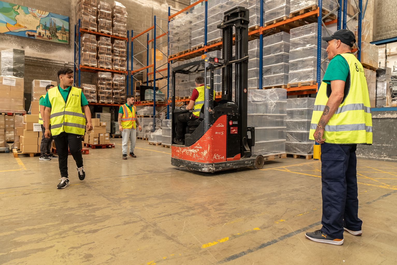 Quatre operaris a l’interior d’un magatzem movent un palet amb urnes que s'utilitzaran per a les eleccions municipals del 28 de maig del 2023.