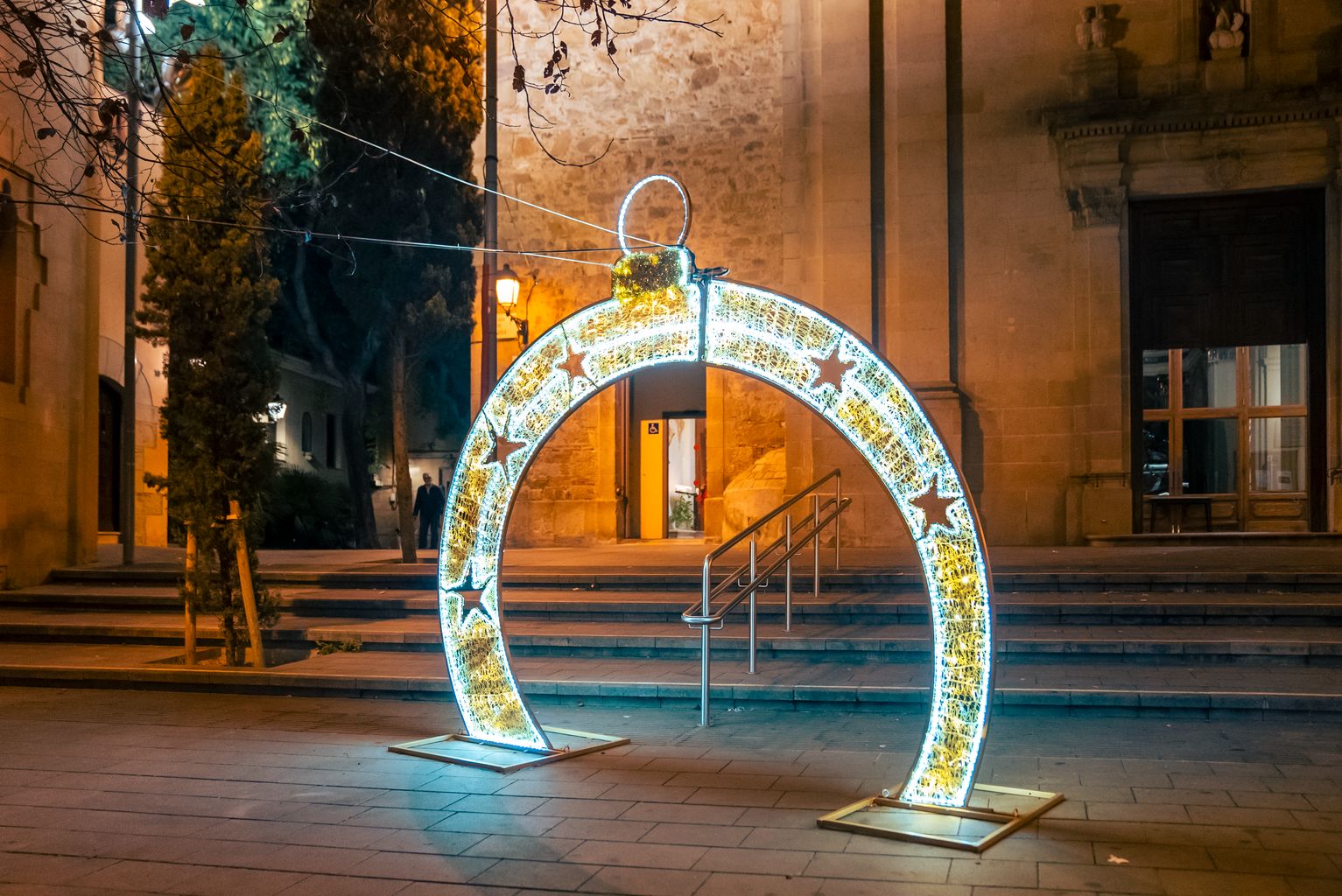 Tótem de luz navideña en forma de bola, iluminado ante la parroquia de Sant Vicenç de Sarrià, en la plaza de Sarrià