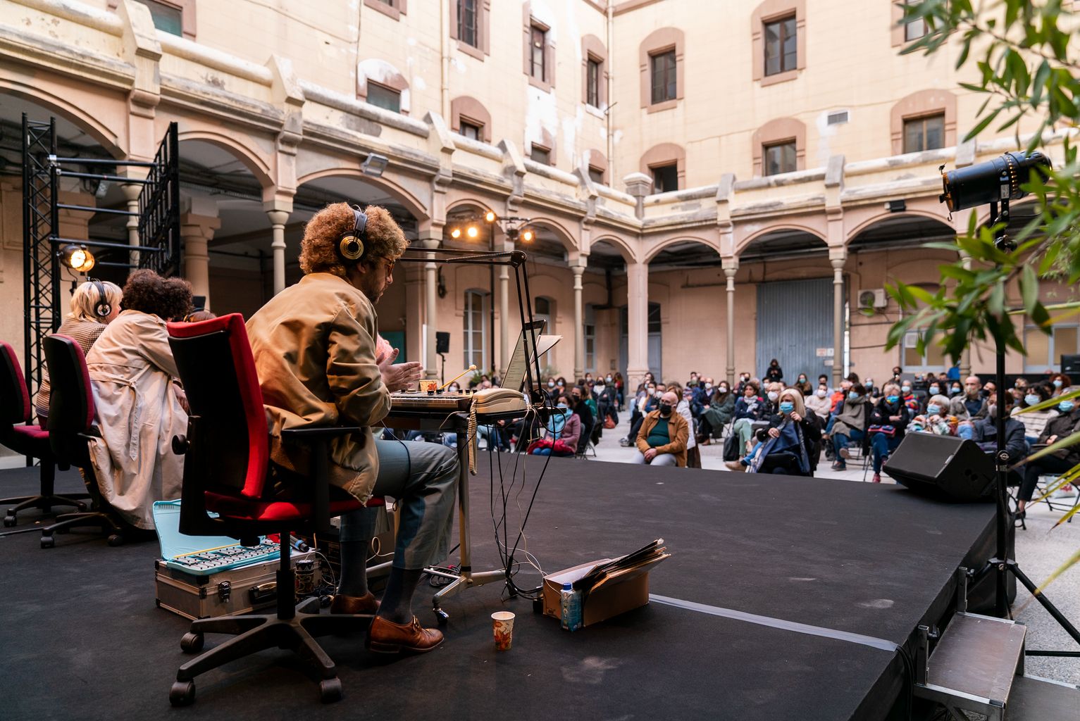 Vista del públic i actors des de darrere de l'escenari a la Model durant la performance Arbres, vodka i naus voladores amb motiu de la Biennal de pensament