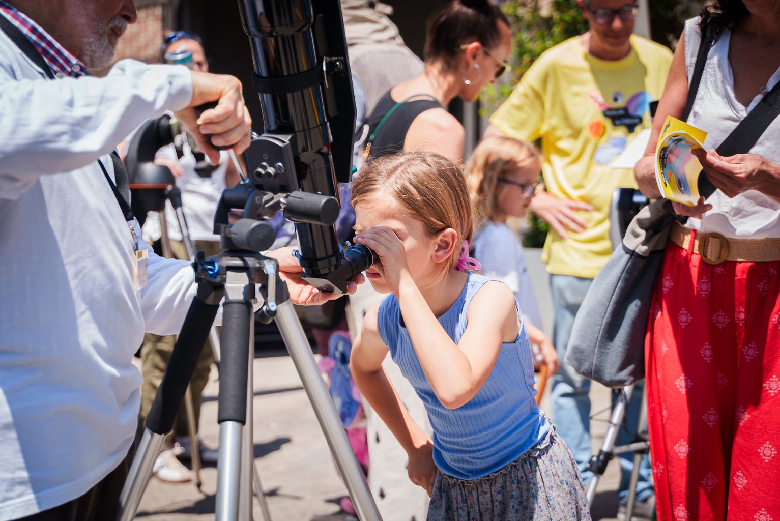Una nena fent una observació solar amb telescopi el dia de la Festa de la Ciència