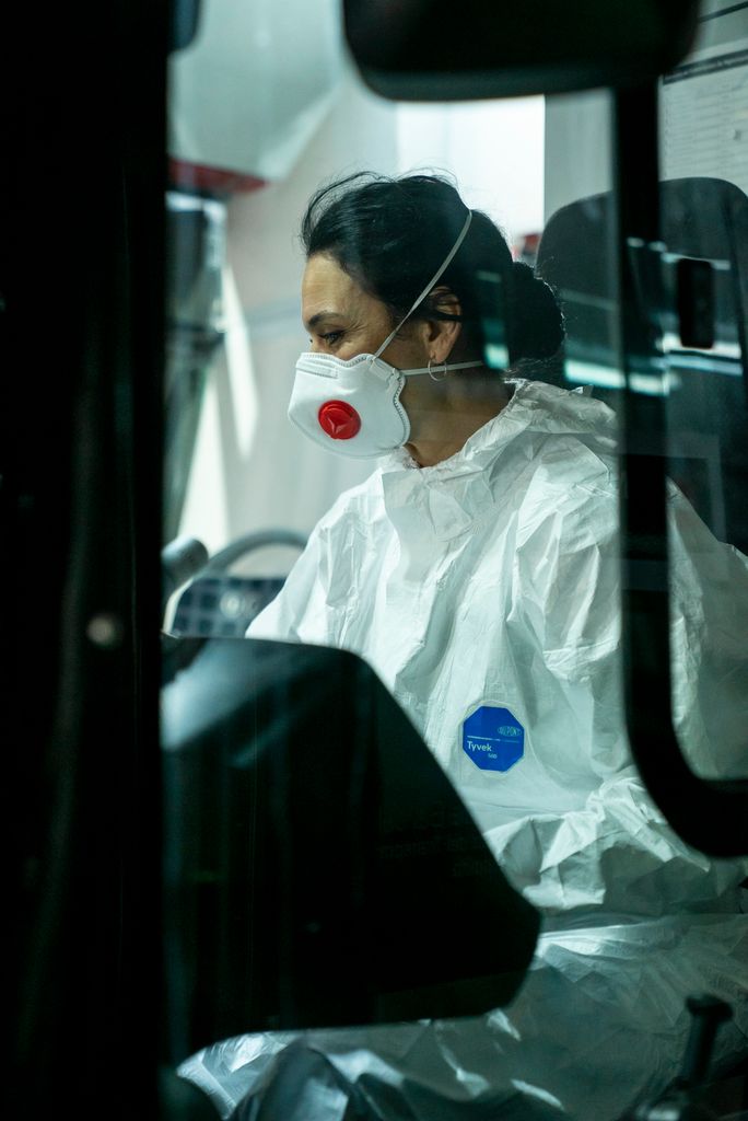 Una de les conductores voluntàries condueix l’autobús vestida amb l’equip de protecció individual