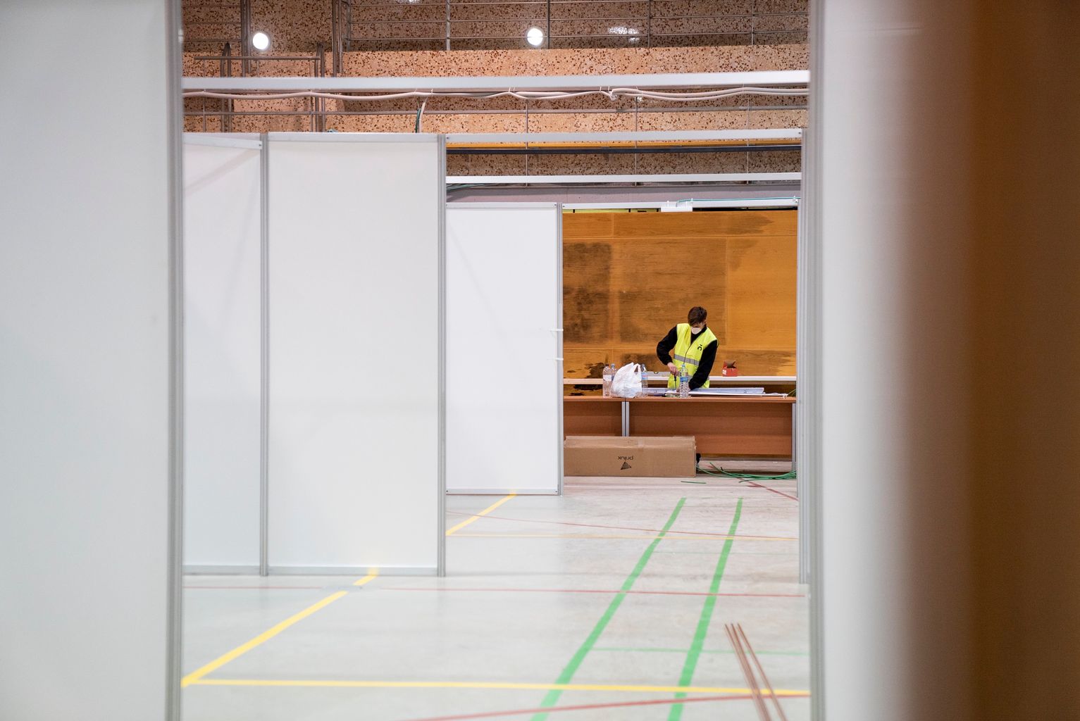 Emplafonat sobre la pista i un treballador al fons muntant unes peces al tauler de treball