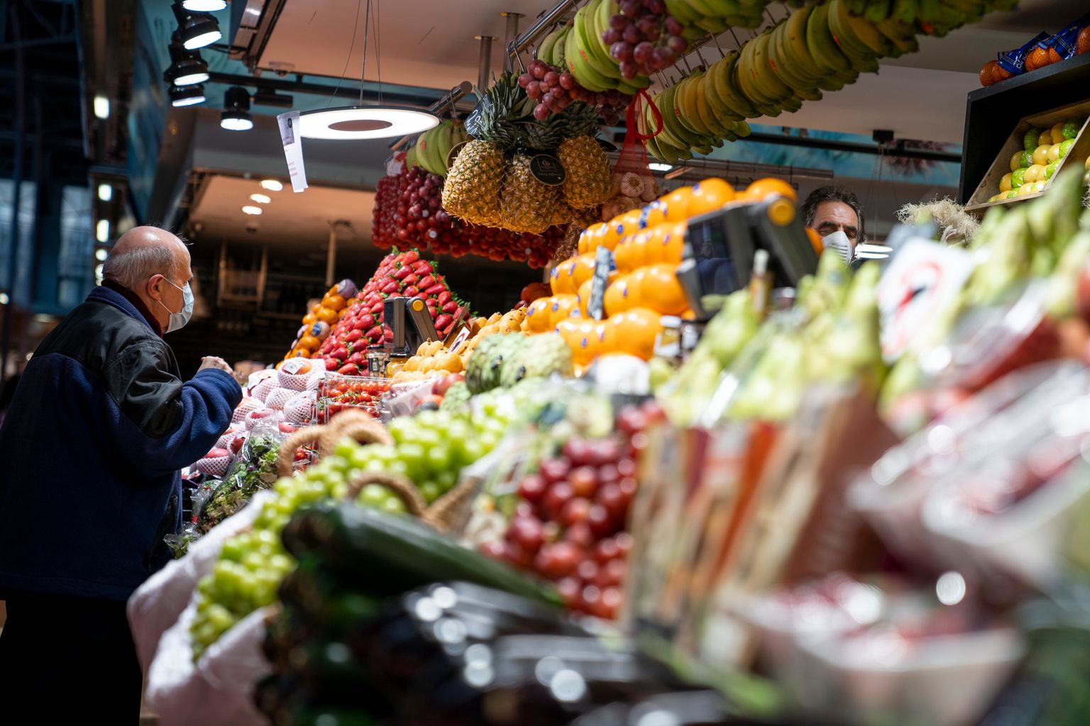 Mercat del Ninot. Un home gran amb mascareta compra fruita i verdura a una parada del mercat