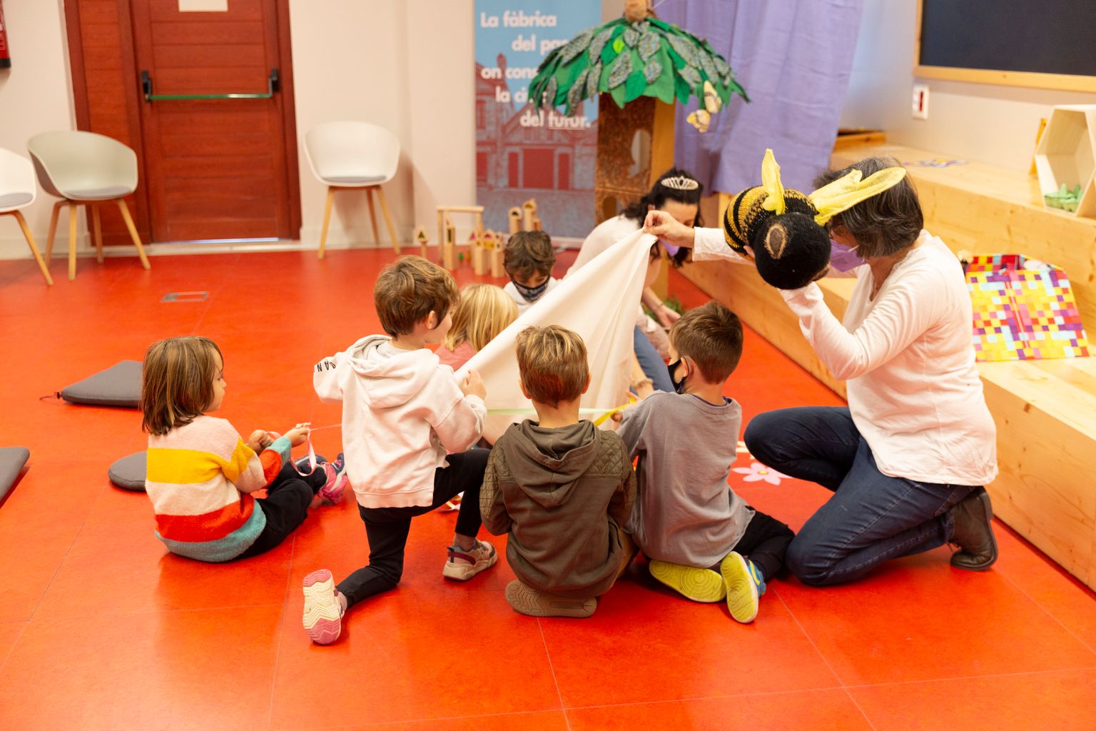 Activitat de contacontes a Ca l'Alier, amb una monitora envoltada d'infants narrant un conte amb ajuda de diferents elements en el marc de la Barcelona Innova Week