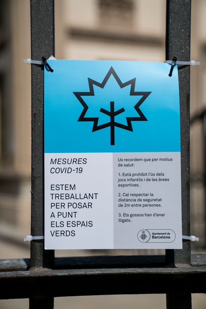 Cartell a la reixa d'un parc on s'avisa de les mesures per la covid-19 i les feines en curs per anar posant a punt els espais verds