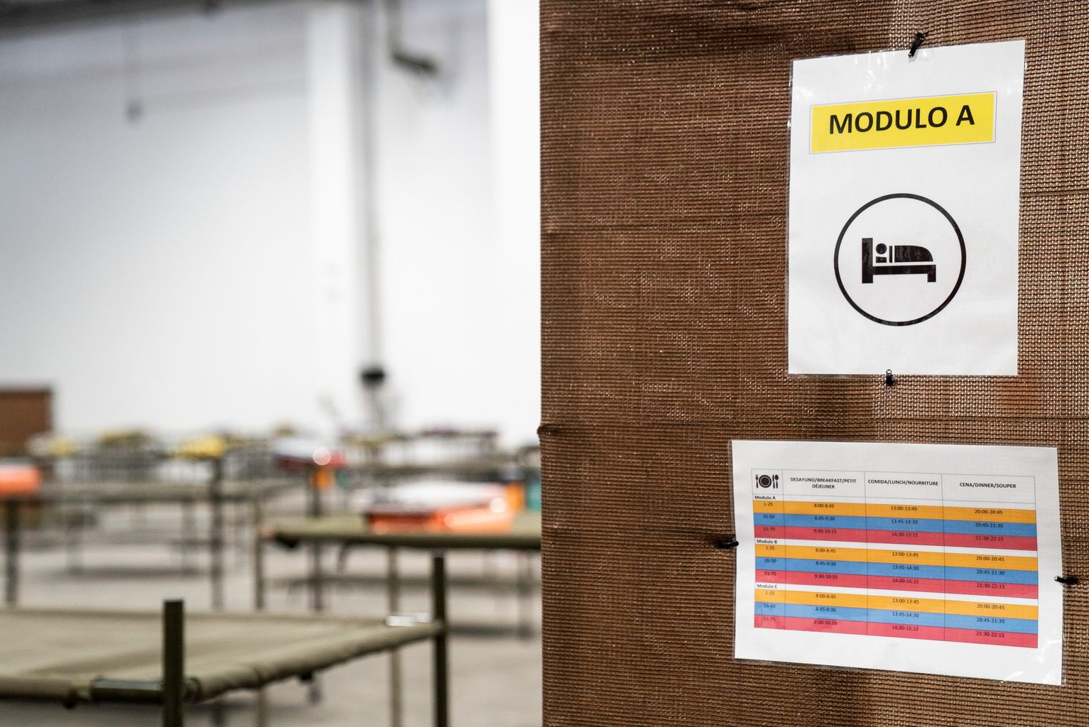 Pavelló per a persones sense llar. Rètol a l’emplafonat amb indicador de “Mòdul A” i els horaris de menjar segons el mòduls