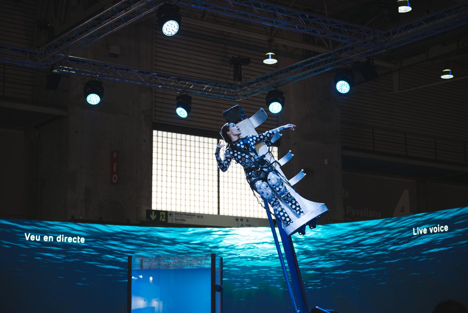 Demostració al Integrated Systems Europe (ISE) 2024, on una noia està enfilada a una grua, sobre una piscina.