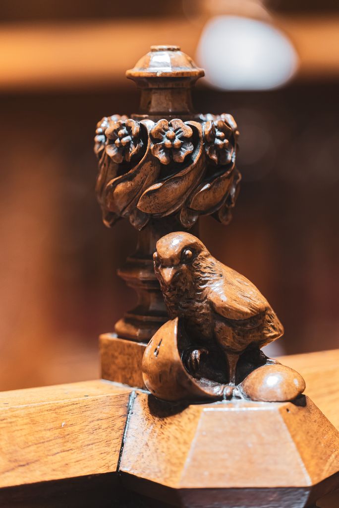 Detall de les talles de fusta dels bancs laterals del Saló de Cent. Escultura d'un ocellet acabat de sortir de l'ou