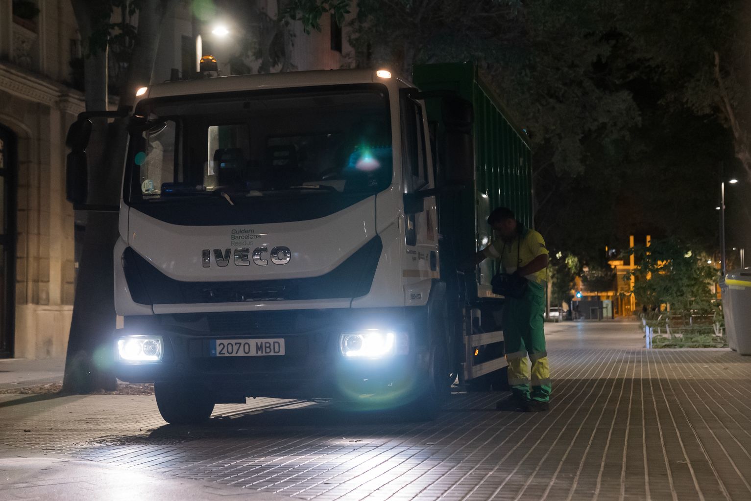 Un camió de Cuidem Barcelona, amb un operari al costat, a l’eix verd de Consell de Cent entre Vilamarí i Entença.