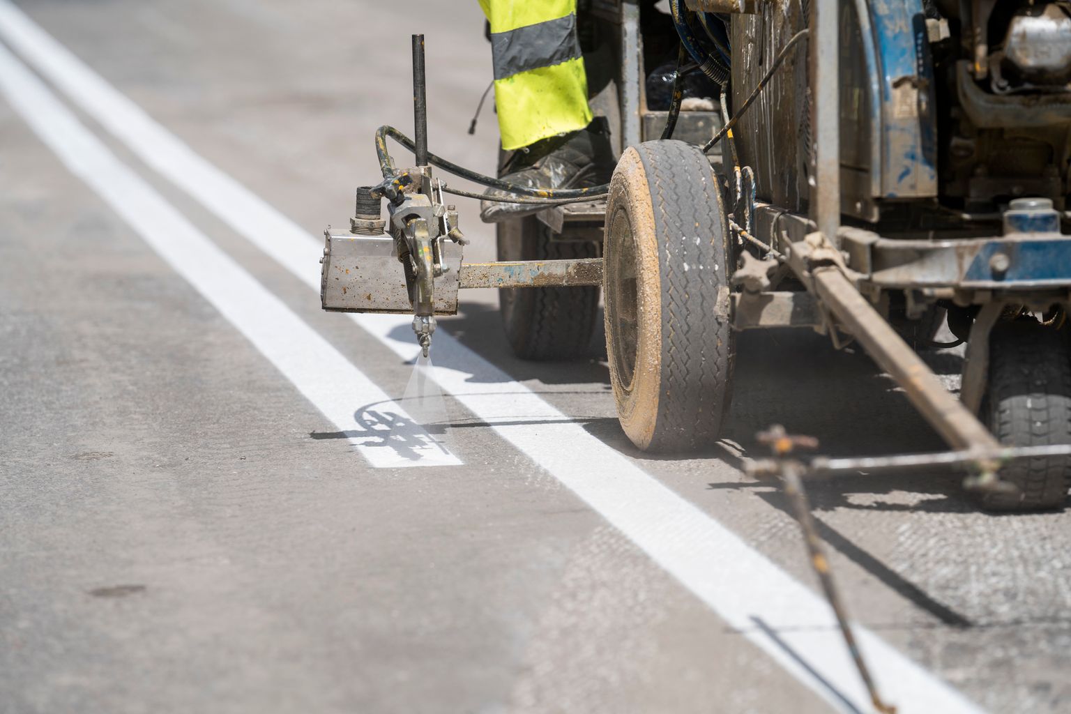 Detalle de la máquina que pinta la doble línea continua sobre el asfalto de la obra de ampliación de aceras de Vía Laietana
