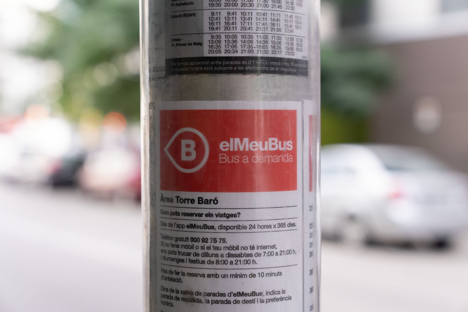Detalle de una parada de bus donde se informa del nuevo servicio de bus a demanda. Observamos que la parada es del área de Torre Baró
