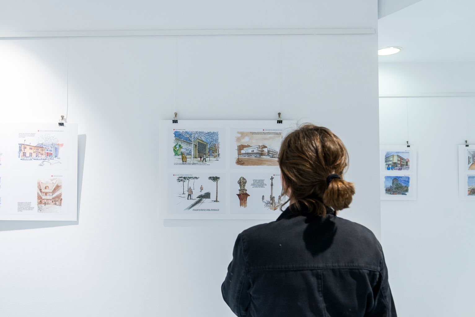 Una chica observa la exposición de los dibujos del cuaderno de viaje "La Verneda de Sant Martí", de Daniel Castro, en el Centro Cívico Sant Martí.