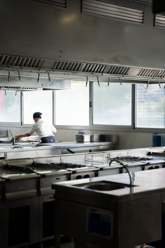 Una persona netejant les cuines de l'Institut de Gastronomia i Restauració de Barcelona