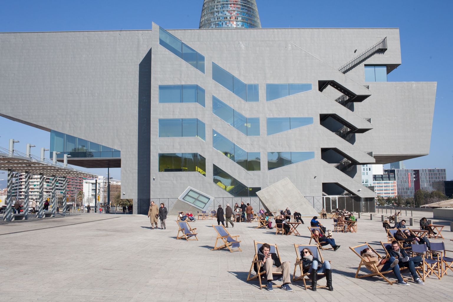 Ciutadania gaudint del sol a les gandules de la Plaça Josep Antoni Coderch