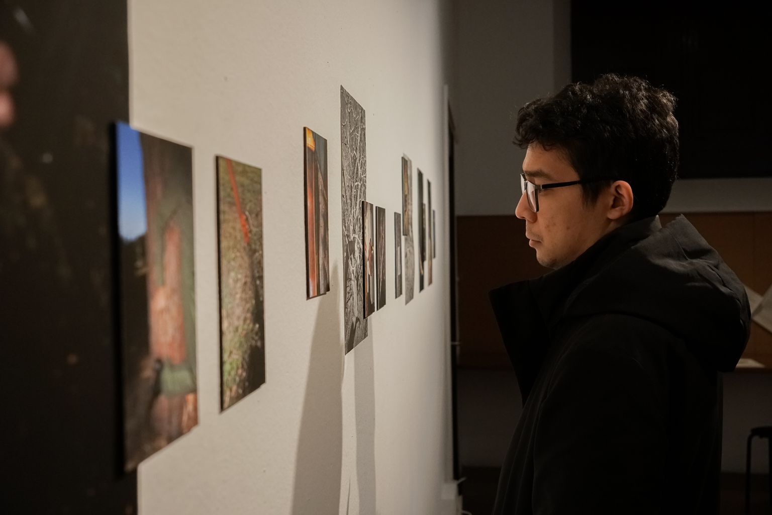 Un noi observa fotografies a la paret de l’exposició «Embolisme per soleá», a la Capella.