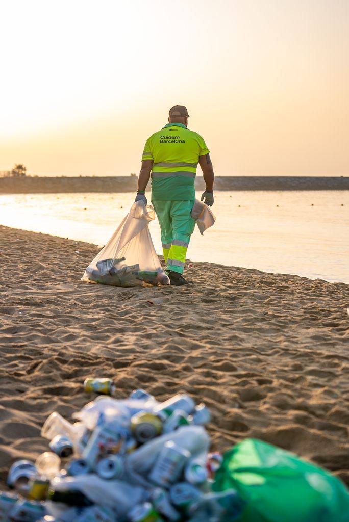 Un home neteja la platja de la Nova Icària, el dia de la revetlla de Sant Joan