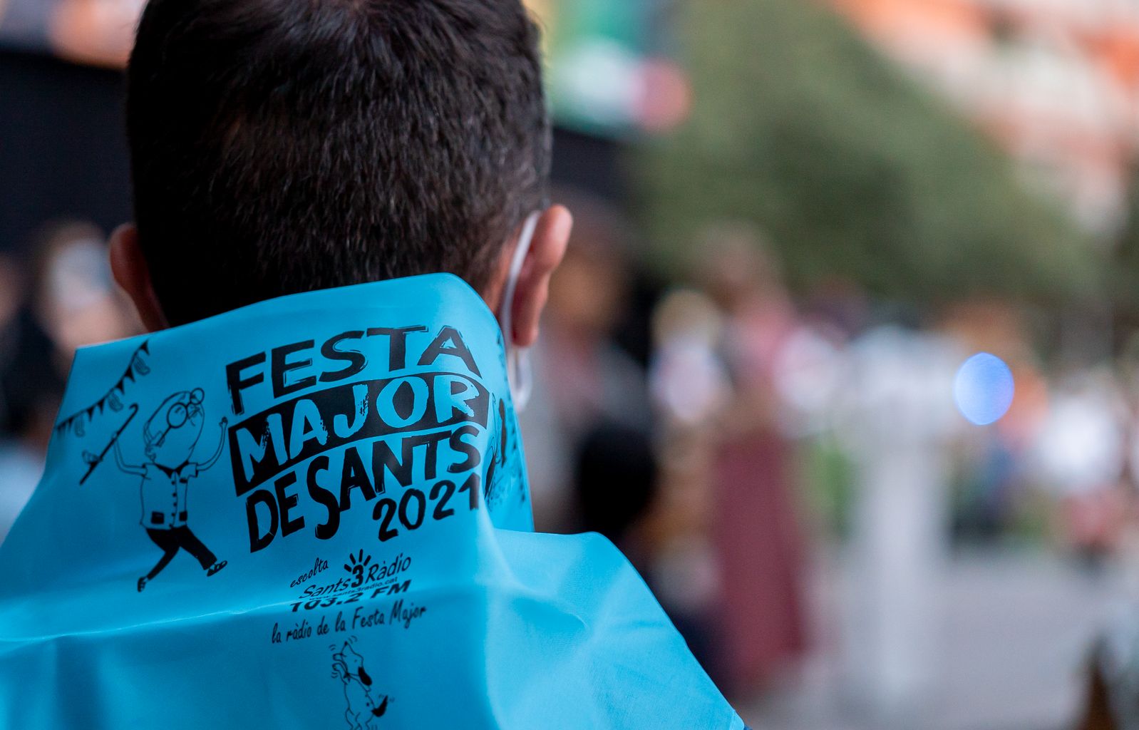 Un dels assistents a l’acte de lectura del pregó de la Festa Major de Sants amb el mocador de la festa