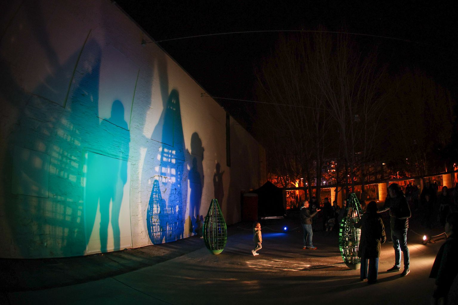 En la pared, las sombras de personas paseando al lado de la obra “Rocking modules”, por Gijs Coenen