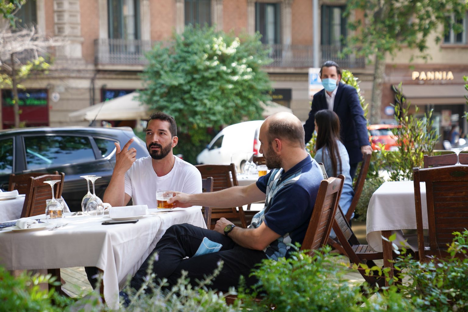 Clients prenent una beguda abans de dinar en un dels nous prototips de terrassa en xamfrà d’un restaurant. El vetllador està envoltat de jardineres i d’una barana protectora que els separa dels vehicles