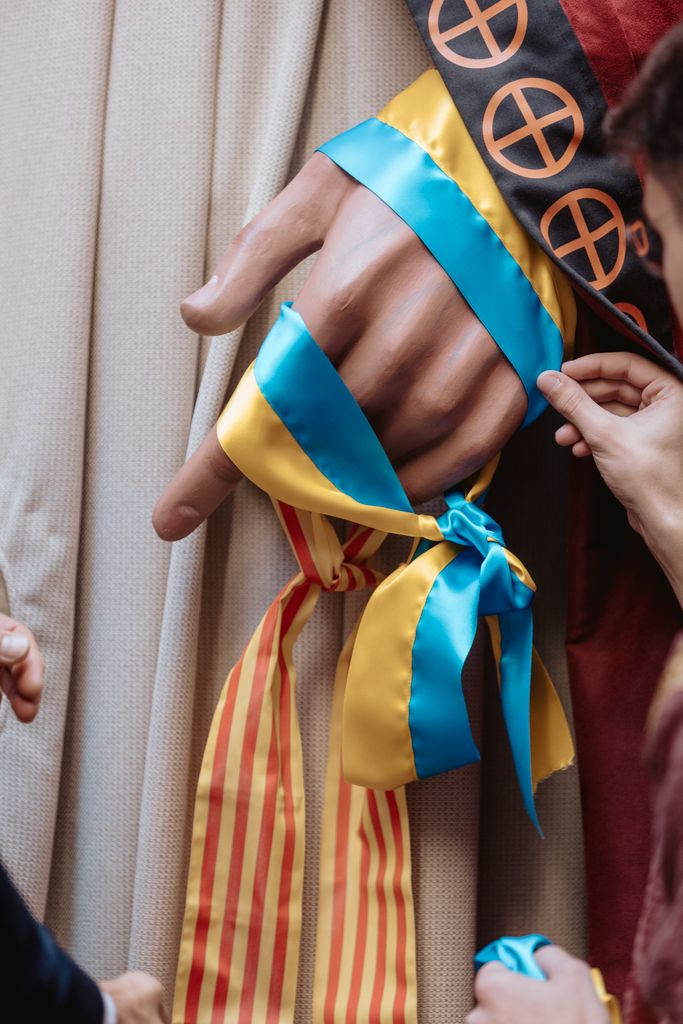 Detalle de las banderas de Ucrania y de Cataluña en manos de uno de los nuevos gigantes de Kyiv durante su acto de bautizo
