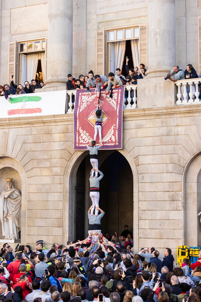 La ‘enxaneta’ de los Castellers del Poble-sec es elevada desde el pilar al balcón del Ayuntamiento