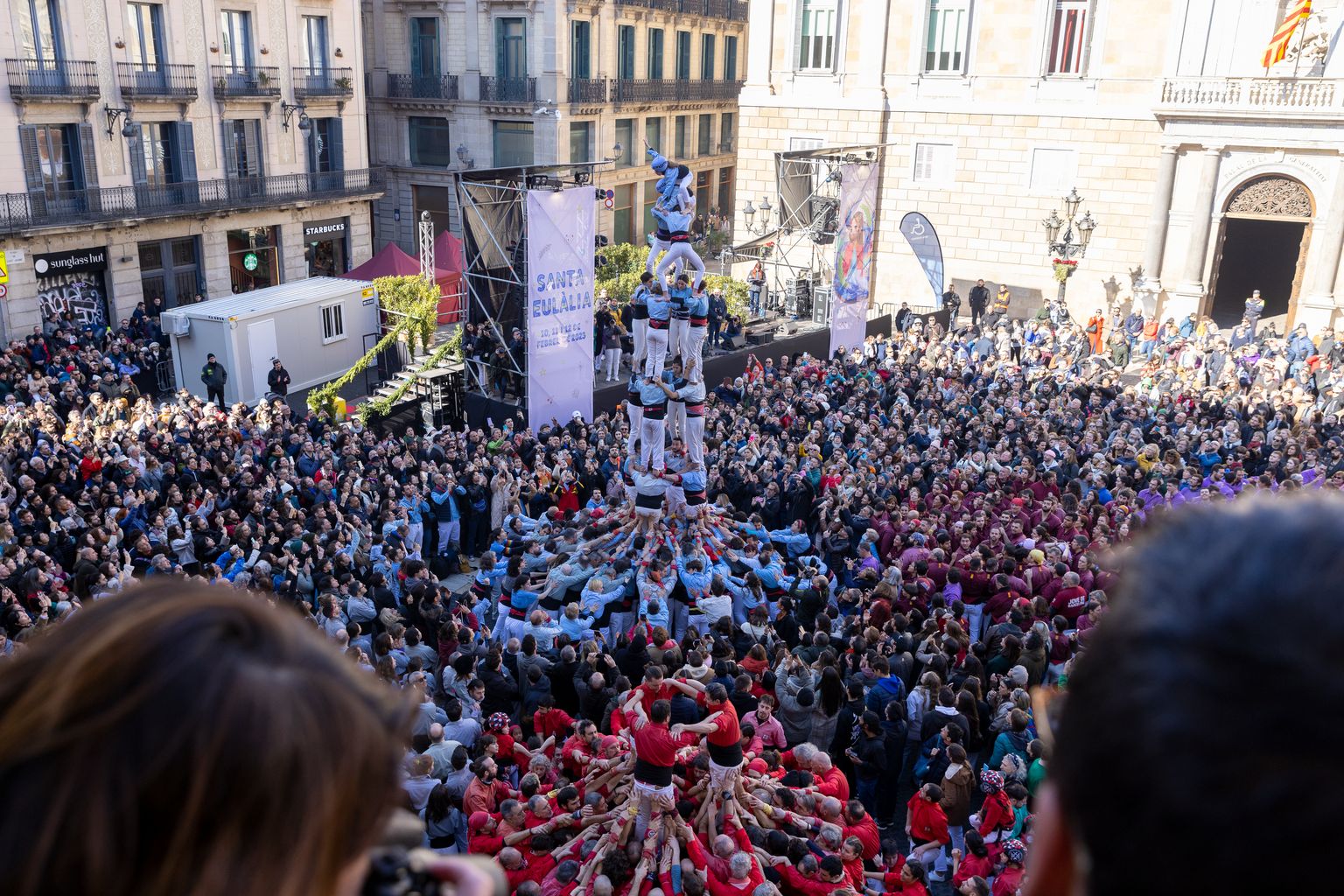 Plano general de la plaza de Sant Jaume, desde el balcón del Ayuntamiento de Barcelona, durante la fiesta ‘castellera’ por Santa Eulàlia. En ese momento, la agrupación ‘castellera’ del Poble-sec hace una construcción humana