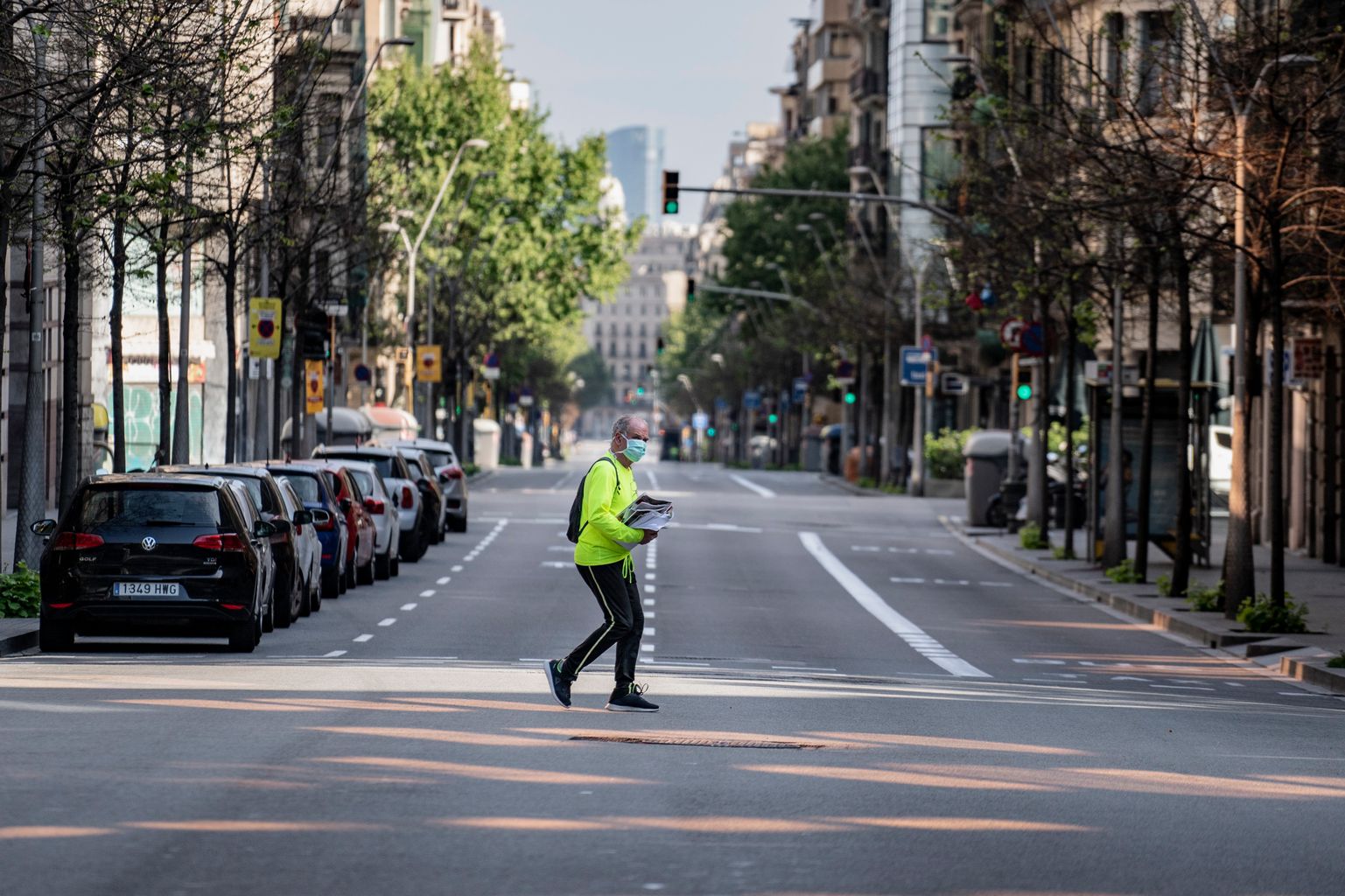 Distrito de L’Eixample. Un hombre mayor cargado con diarios cruza la calle de Balmes