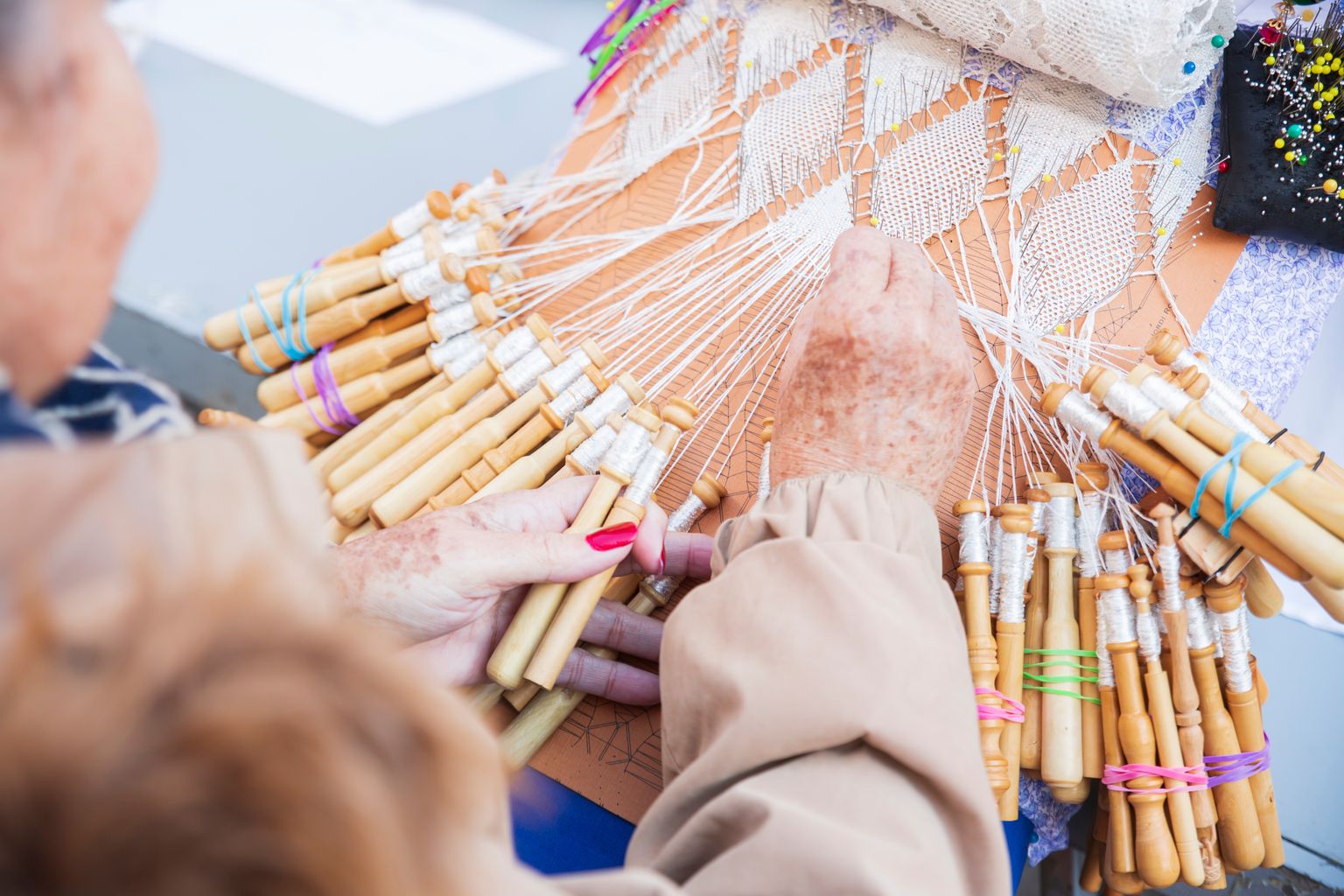 Una puntaire confecciona unes puntes de coixí durant la trobada amb motiu de Santa Eulàlia