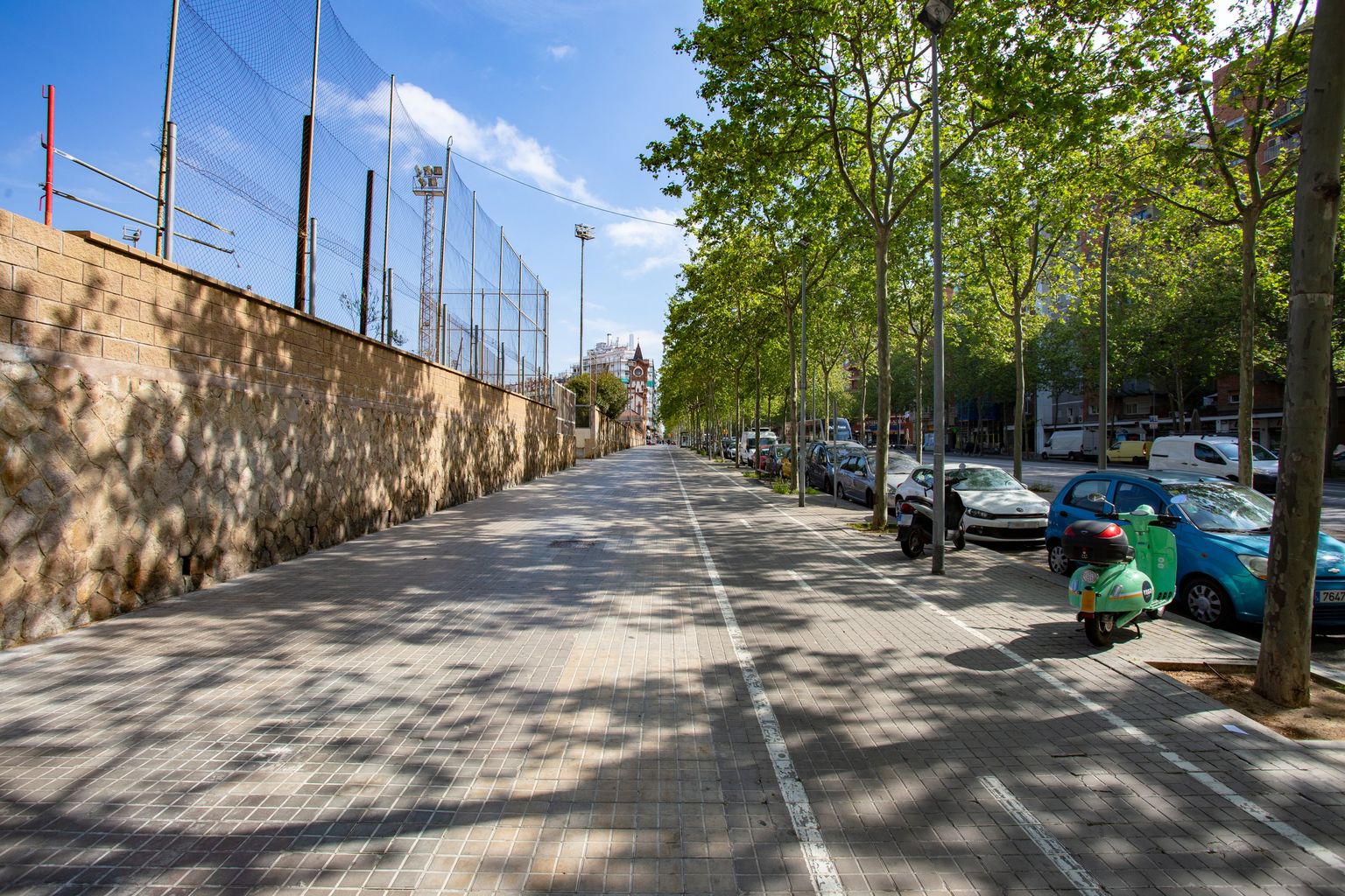 Gran Via de les Corts Catalanes prop de l’antiga estació de la Magòria. La vorera està totalment buida de gent i només s’hi veu alguna motocicleta aparcada. Districte de Sants-Montjuïc. Barri de la Bordeta.