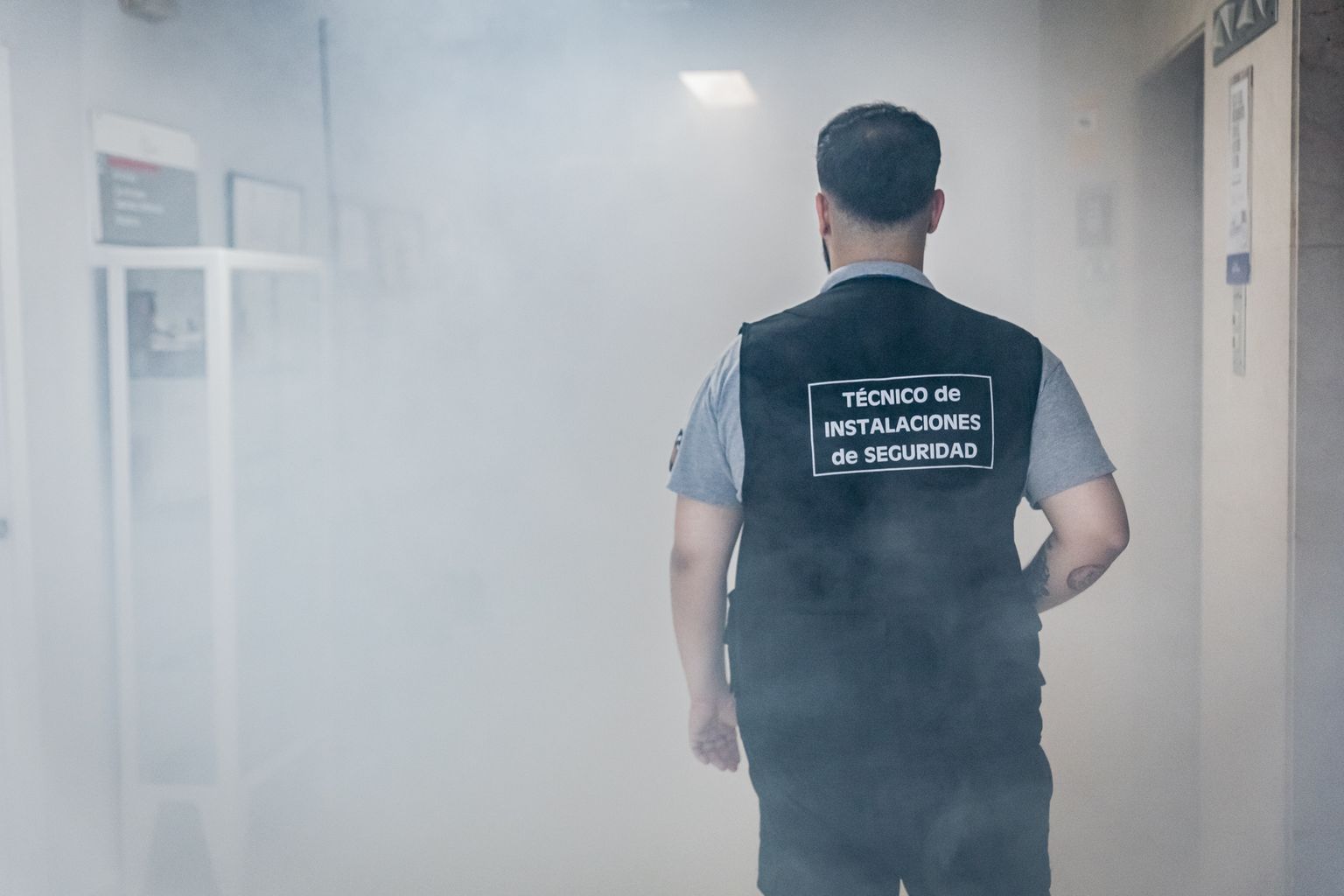 Un tècnic d’instal·lacions de seguretat camina entre el fum per un passadís de l’Hospital de la Vall d’Hebron en un simulacre.