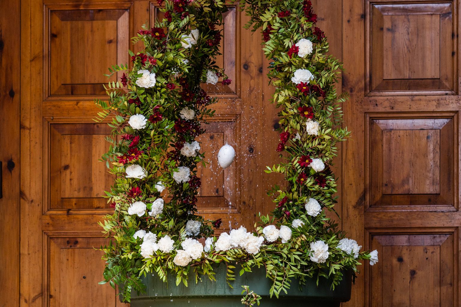 L'ou com balla a la plaça de la Virreina, on hi ha una font decorada amb flors amb motiu de la festa del Corpus davant de les portes de l'església de Sant Joan