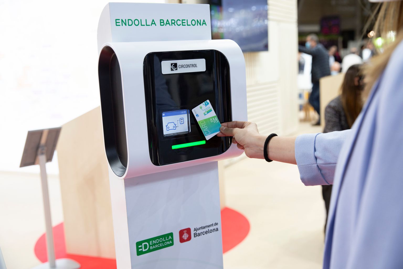 Un visitant prova amb una targeta el carregador elèctric per a cotxes de l'Endolla Barcelona a l'Smart City Expo World Congress