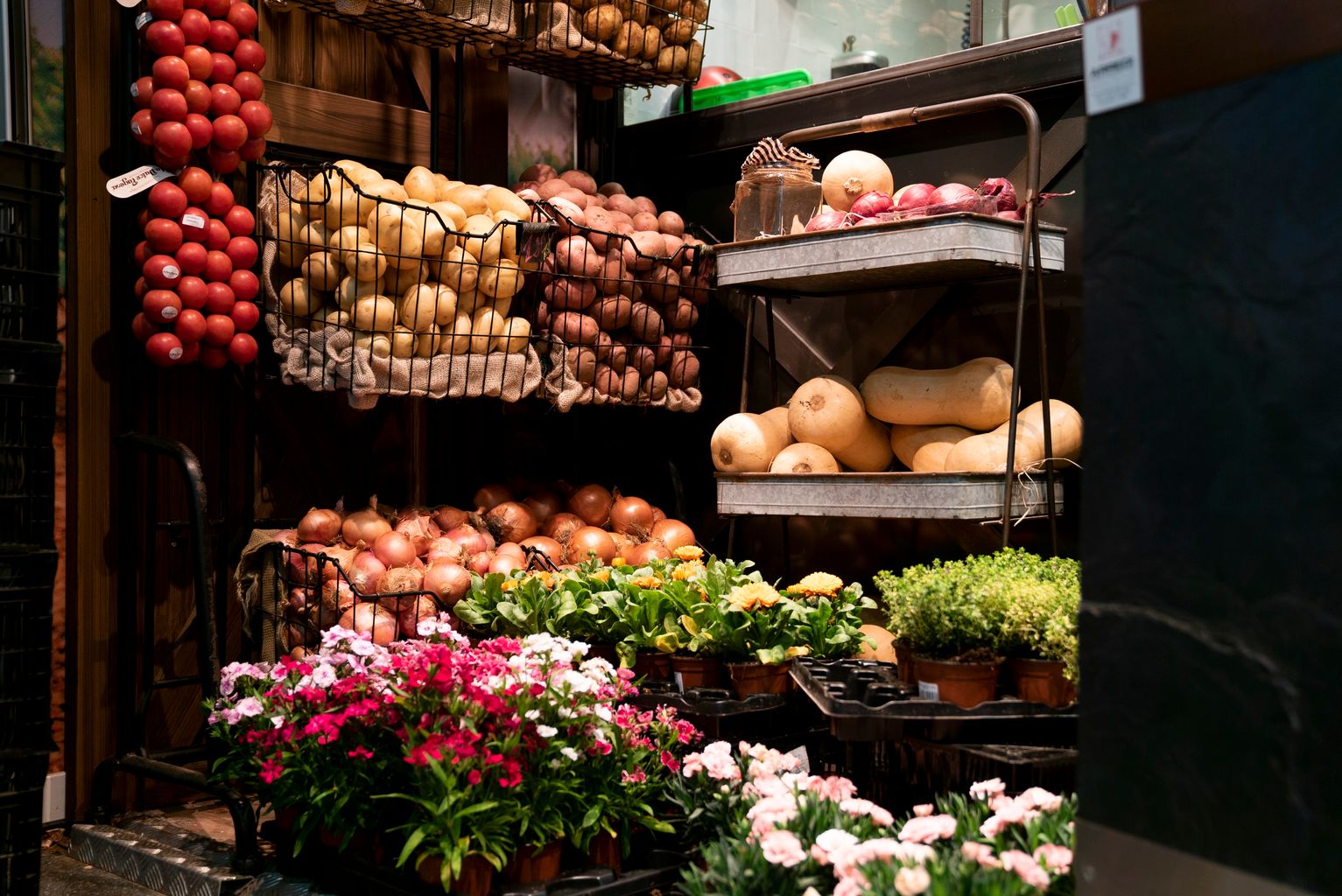 Parada de fruites i verdures del Mercat de Sant Antoni amb torretes de flors de la campanya "Planta'm al balcó"