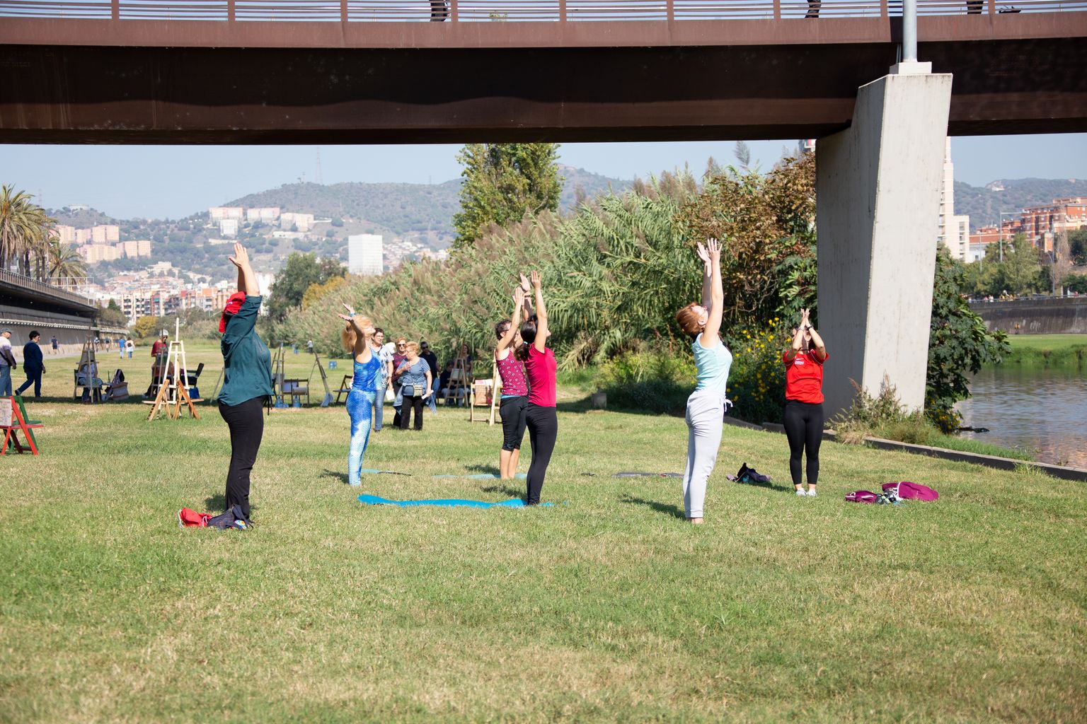 Un grupo de chicas practica yoga durante la fiesta “Va de Besòs” en el Bon Pastor y el puente del Molinet de Barcelona.