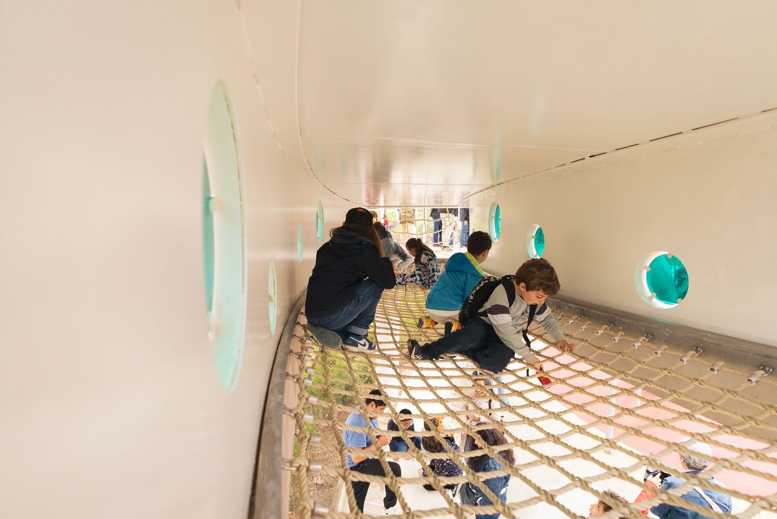 Red del nuevo nodo dinámico del parque de las Glòries con niños caminando por encima el día de la inauguración del parque