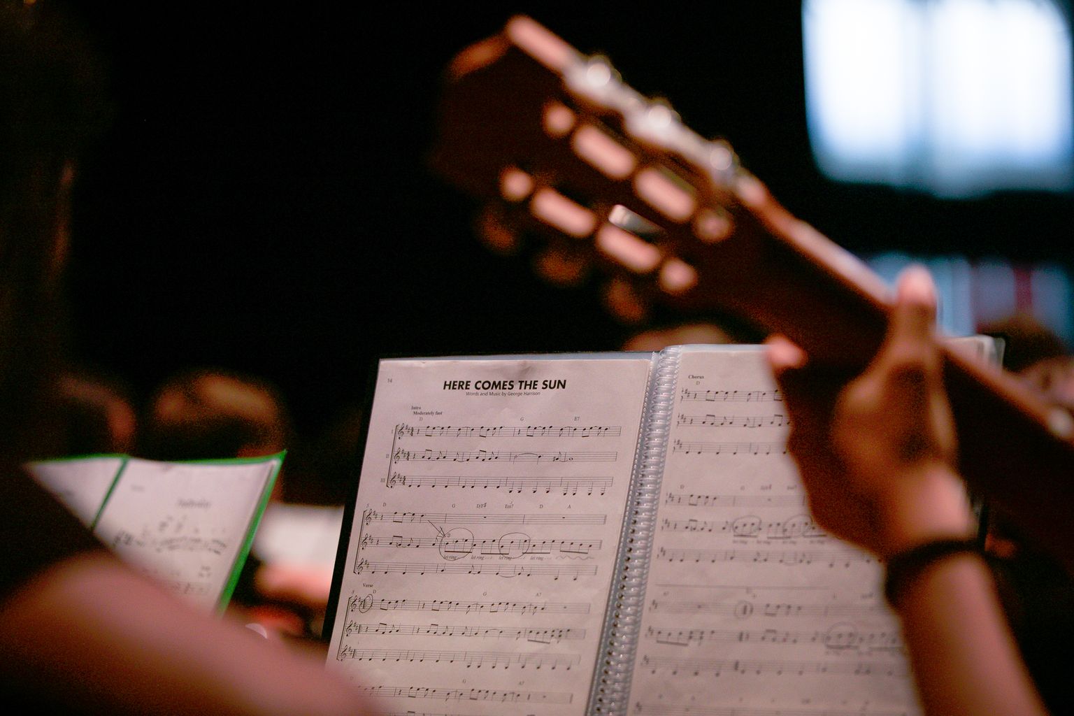 Alumnes tocant amb guitarres la partitura de ‘Here comes the sun’.