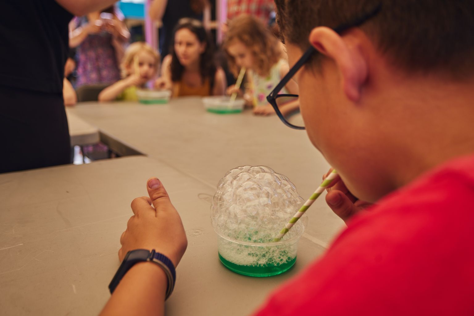 Un infant fa unes bombolles en una de les activitats de 16a Festa de la Ciència a la Rambla de Prim.