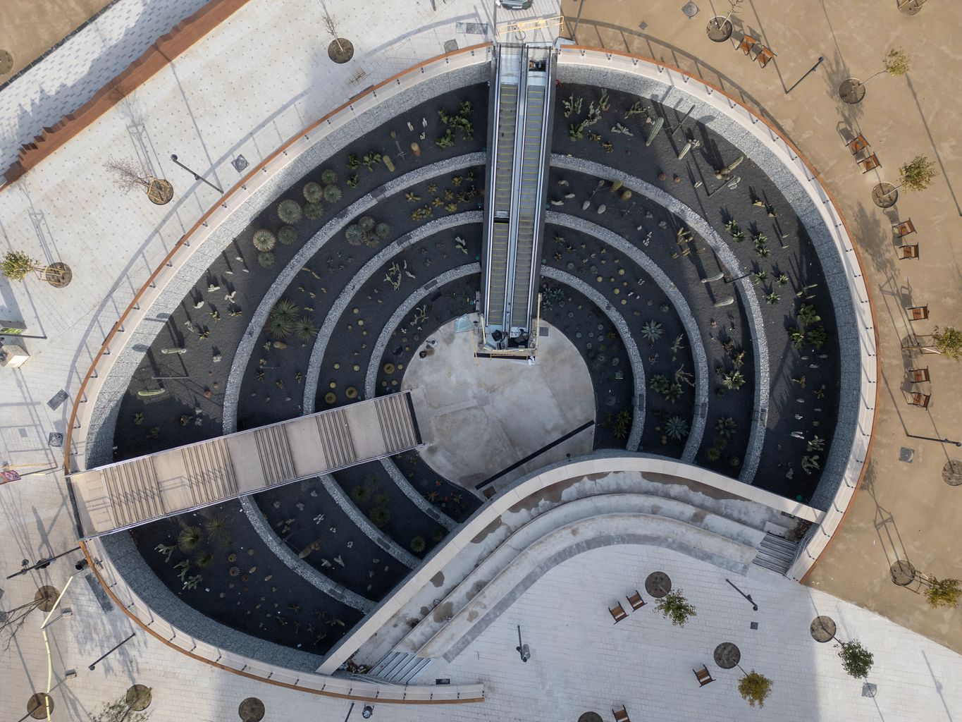Vista aérea del jardín de inmersión del nuevo parque de las Glòries que tiene una grada como mirador y da acceso al metro y está rodeado de un jardín de cactus