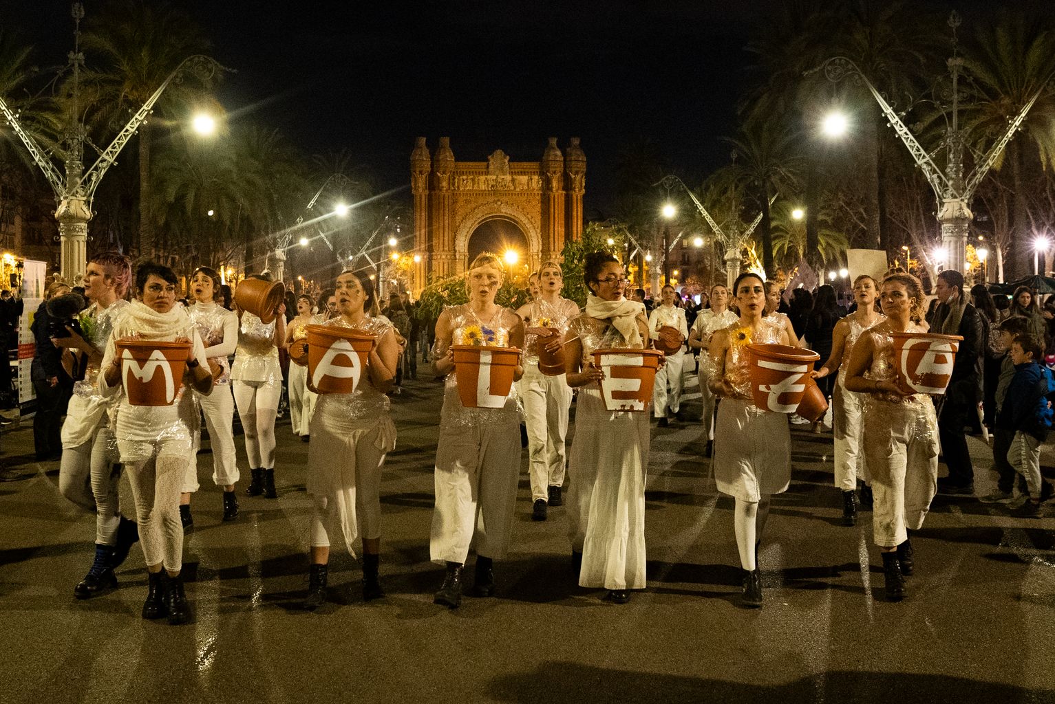 Grup de manifestants vestides de blanc portant unes lletres que formen la paraula "Maleza"a la manifestació del Dia Internacional de les Dones pel passeig de Sant Joan