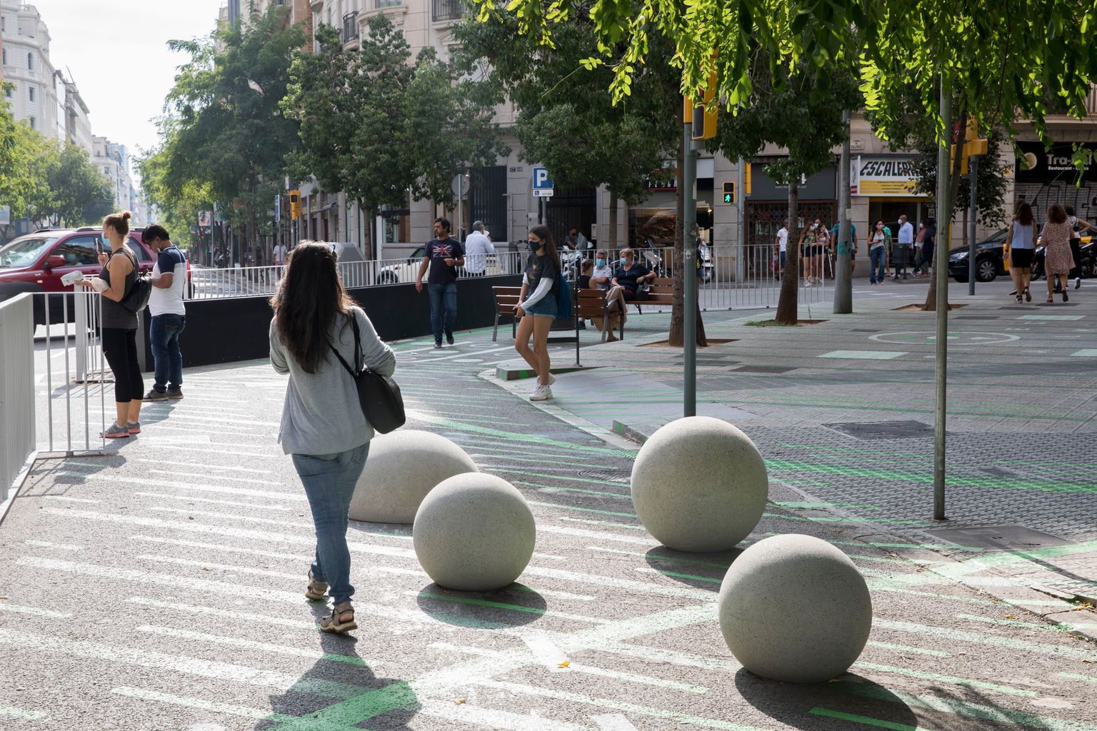 Zona pacificada davant de l’Escola Pia Balmes amb esferes i semiesferes de formigó, una barana de separació del trànsit, ampliació de les voreres i jardineres