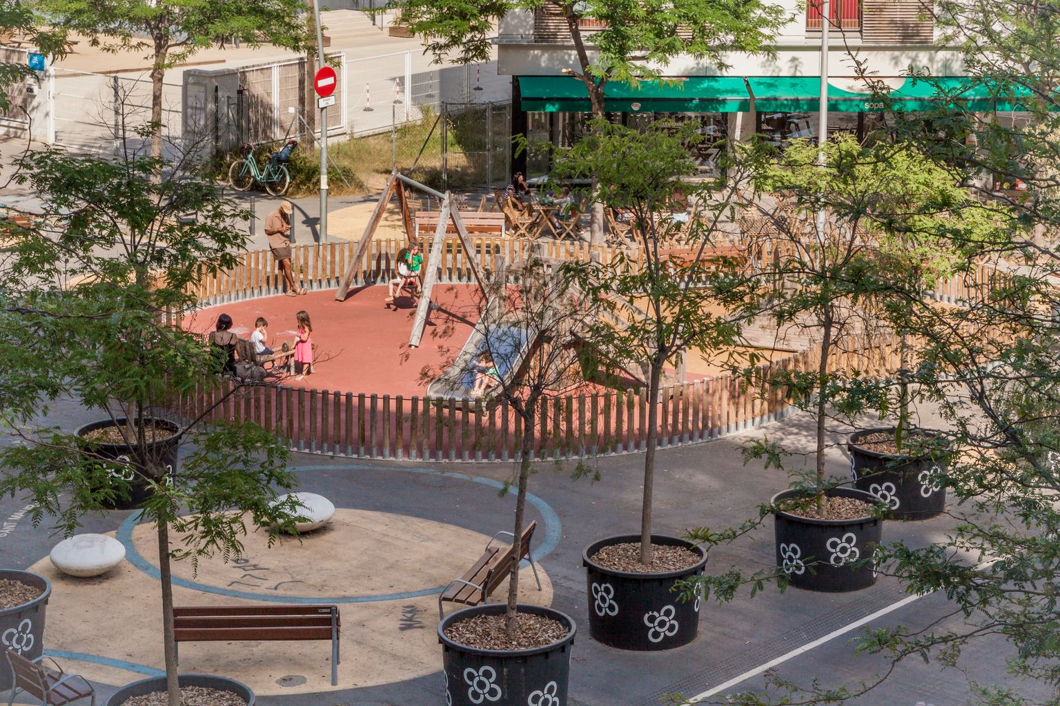 Nens jugant als gronxadors de la zona de joc infantil de la superilla del Poblenou, a la cruïlla del carrer de Sancho de Ávila amb Ciutat de Granada