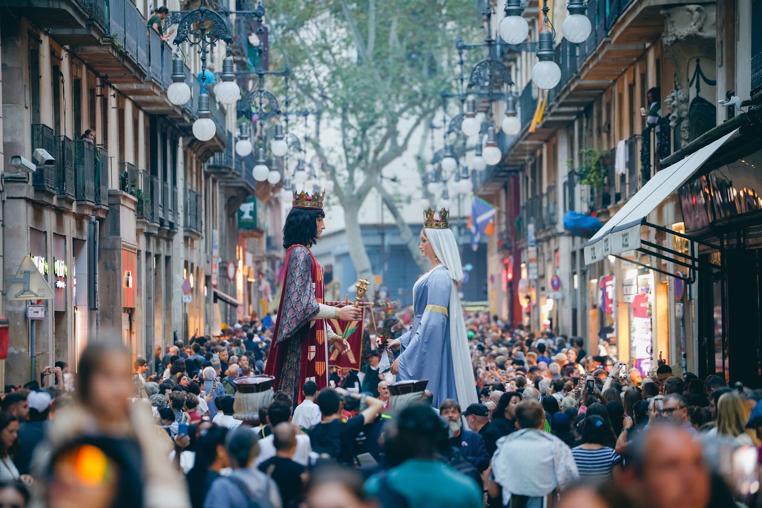 Gegants de la Ciutat desfilant pel carrer de Ferran envoltats de públic dirigint-se a la plaça de Sant Jaume pel toc d'inici de la Mercè 2024