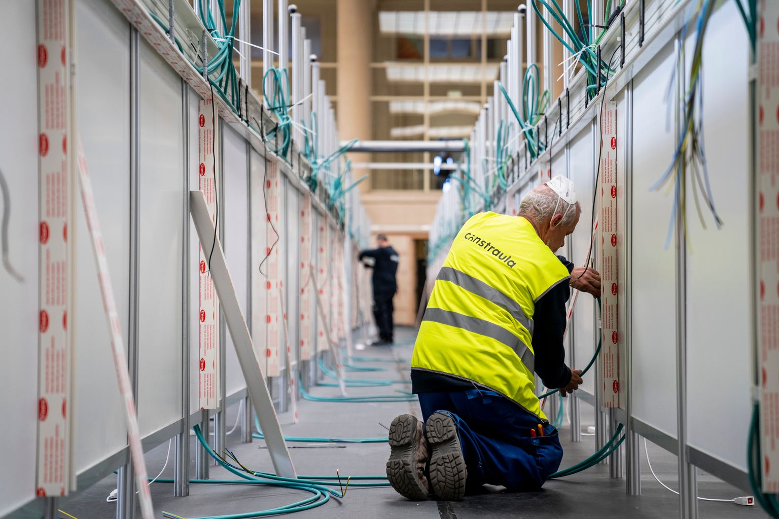 Pavelló Salut INEFC. Els instal·ladors elèctrics posen el cablejat al Pavelló assegurant-lo dins de regletes