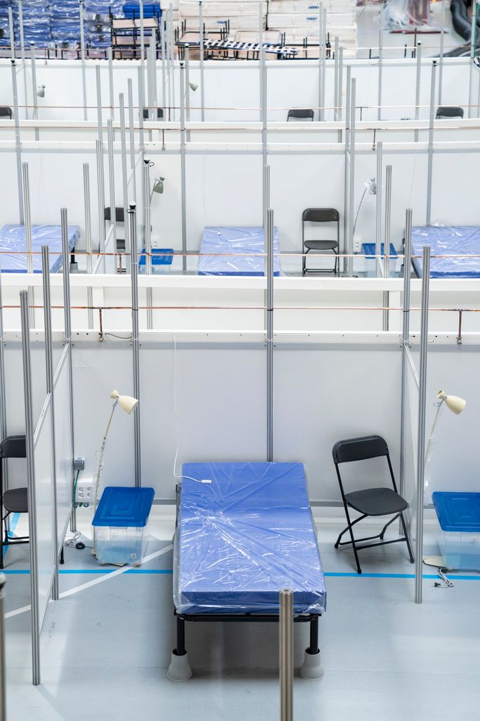 Pavelló Salut INEFC. Detall d’un dels boxs amb una tauleta, un llum, el llit i una cadira plegable