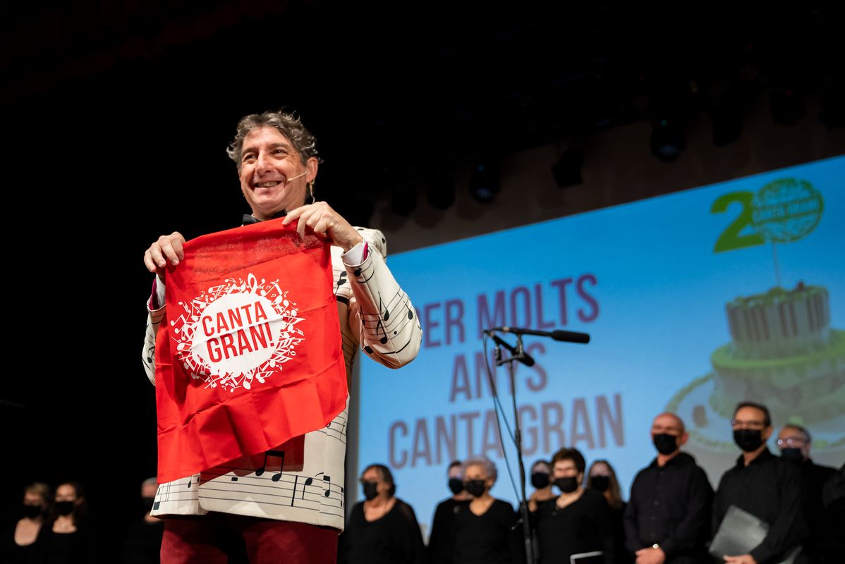 
             El conductor del acto mostrando el pañuelo promocional del  