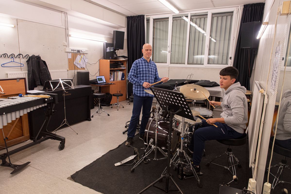 
             Un jove toca la bateria amb el seu professor de l